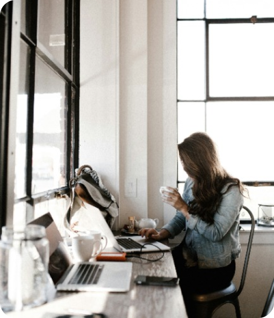 Woman Sitting at a Desk holding a cup